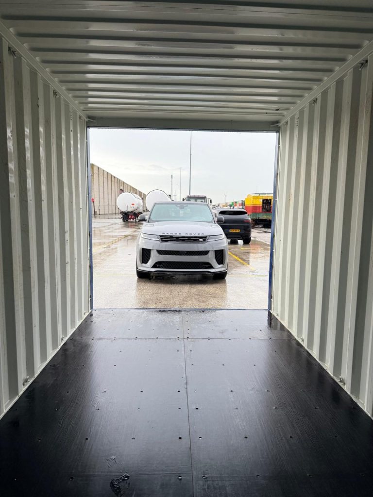 Personenauto wordt in een zeecontainer geladen